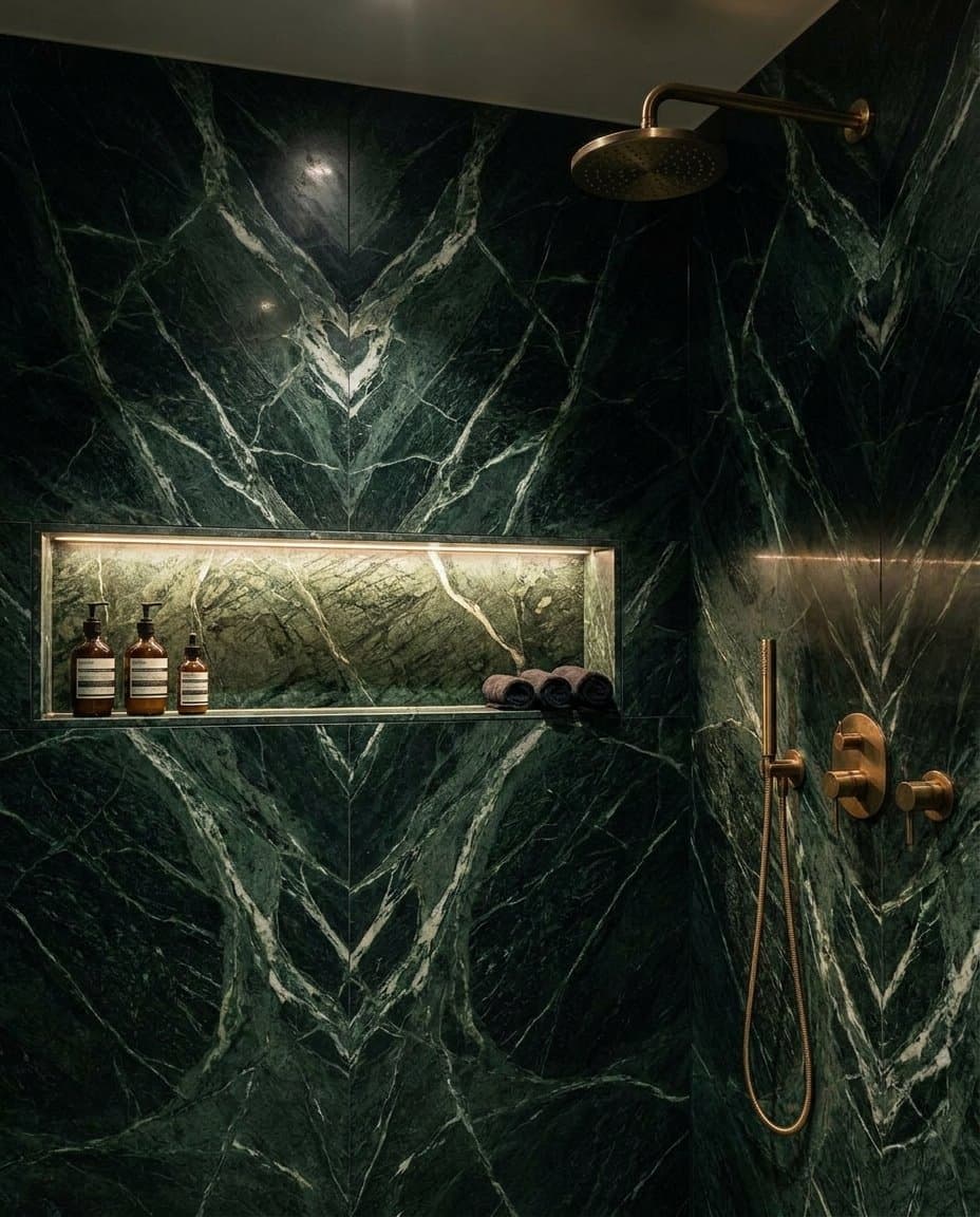 Green marble shower with book-matched veining and a lit horizontal niche